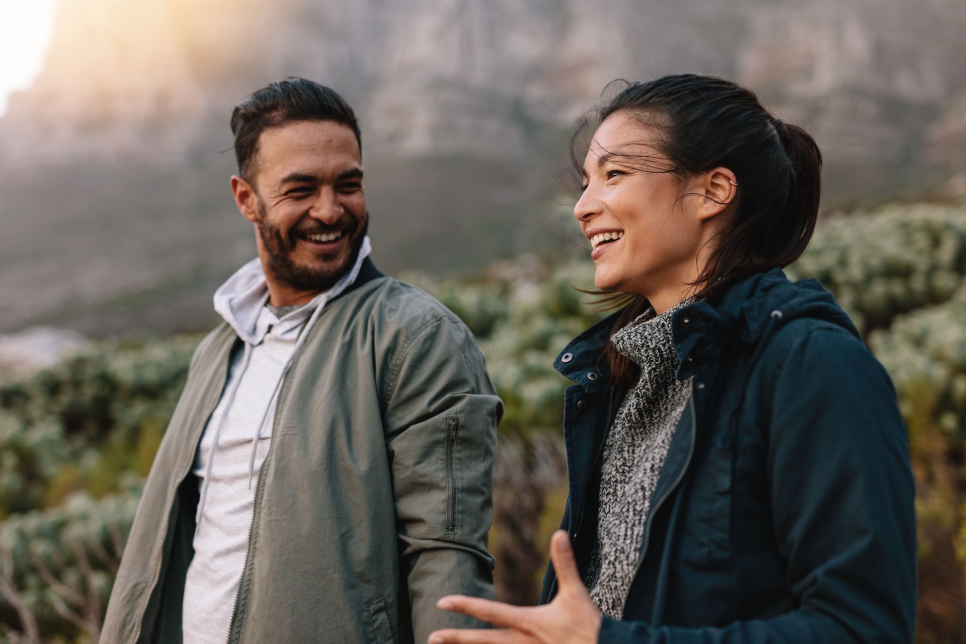 Feliz pareja caminando y hablando en el campo